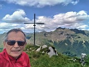 65 Alla croce di vetta della Corna Grande (2089 m) con vista sul Pizzo Tre Signori (2554 m)